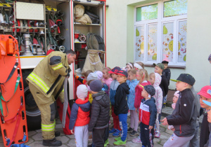 Strażak prezentuje dzieciom sprzęt strażacki