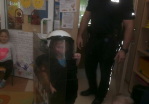 Dziewczynka przymierza strój policjanta.