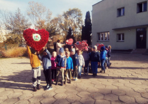 Dzieci idą pod pomnik Jana Pawła II.