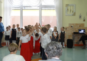 Dzieci tańczą poloneza dla mieszkańców domu.