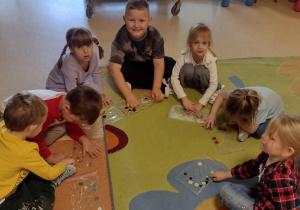 Motylki układają wzory z guzików w żelowych woreczkach