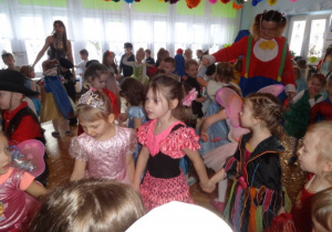 Dzieci w przebraniach tańczą na balu.