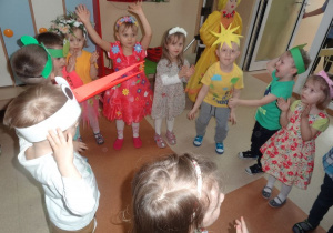 Dzieci w strojach z akcentem wiosennym tańczą.