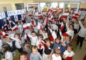 Dzieci machają flagami.