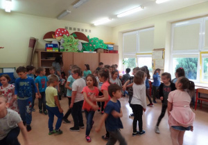 Przedszkolaki tańczą z uczniami.