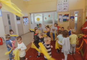 Dzieci tańczą z żółtymi chustkami.