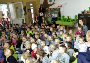 Dzieci oglądają film edukacyjny o dinozaurach.