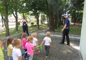 Dzieci idą na spacer z policjantem.